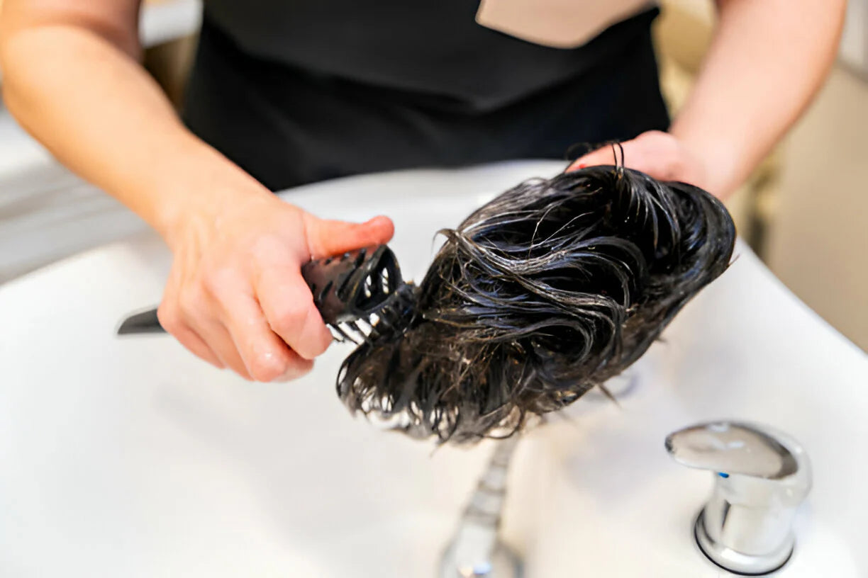 a woman washing a human hair wig